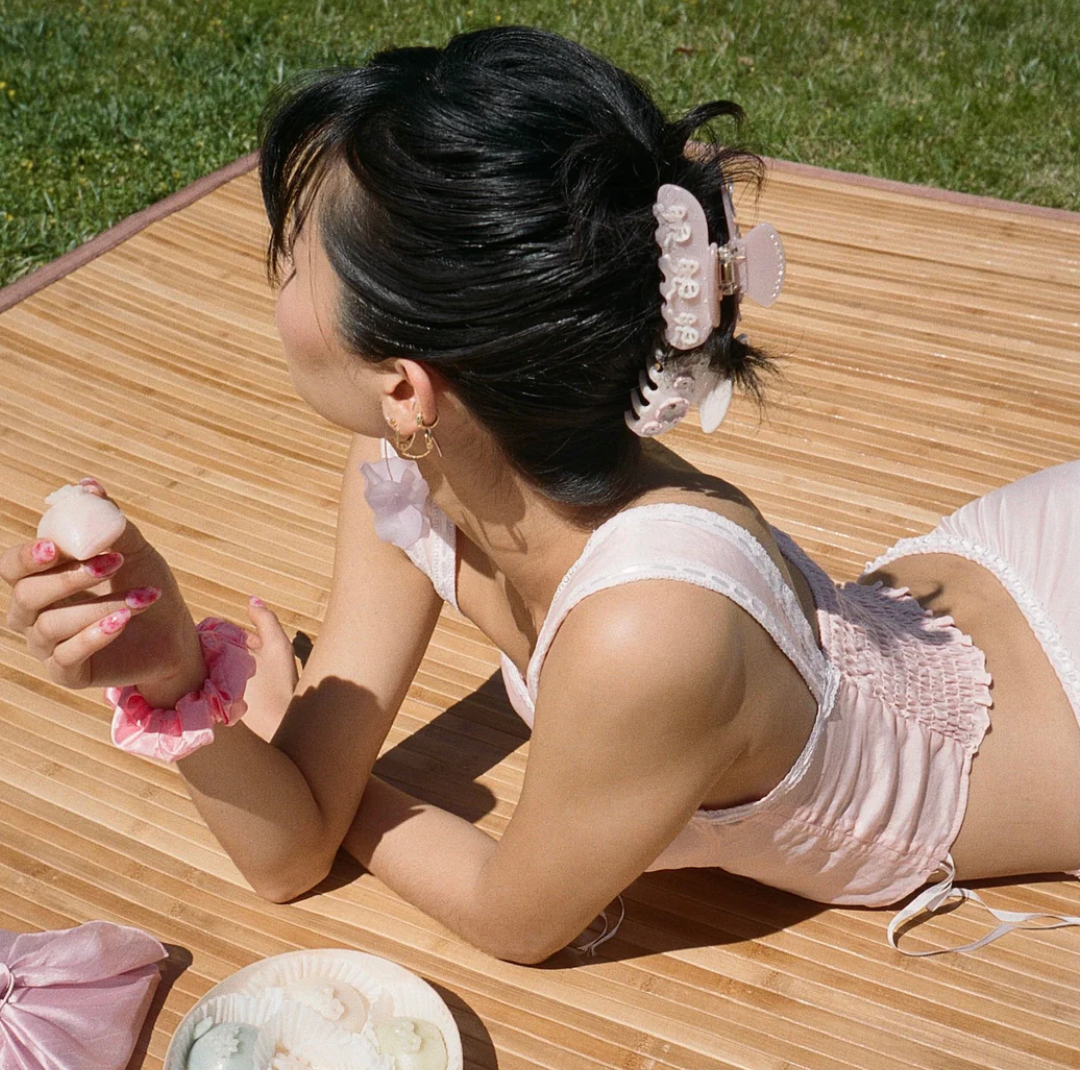 Girl laying down wearing the pink pixie hair clip