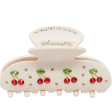 Cream hair claw clip with red cherries on a white background