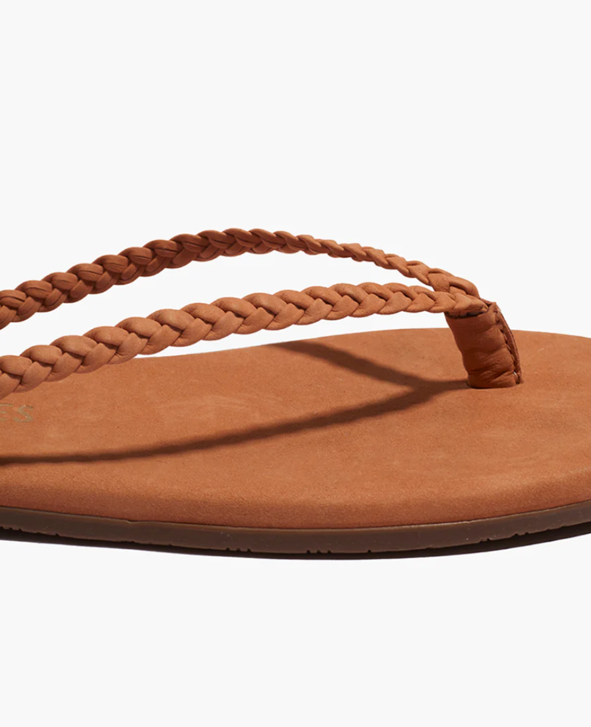 Brown sandal with braided strap on a white background