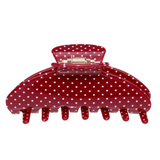Red polka dot hair clip on a white background
