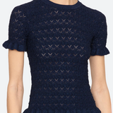 Navy blue patterned sweater worn by a person on a white background.