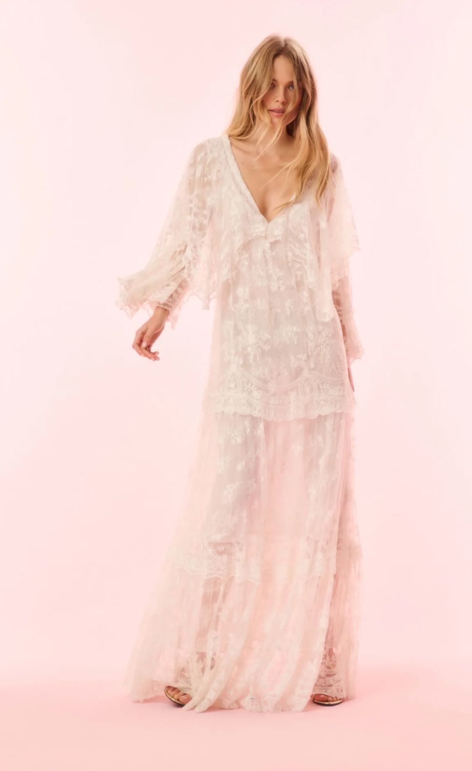 Woman wearing a white lace dress on a pink background
