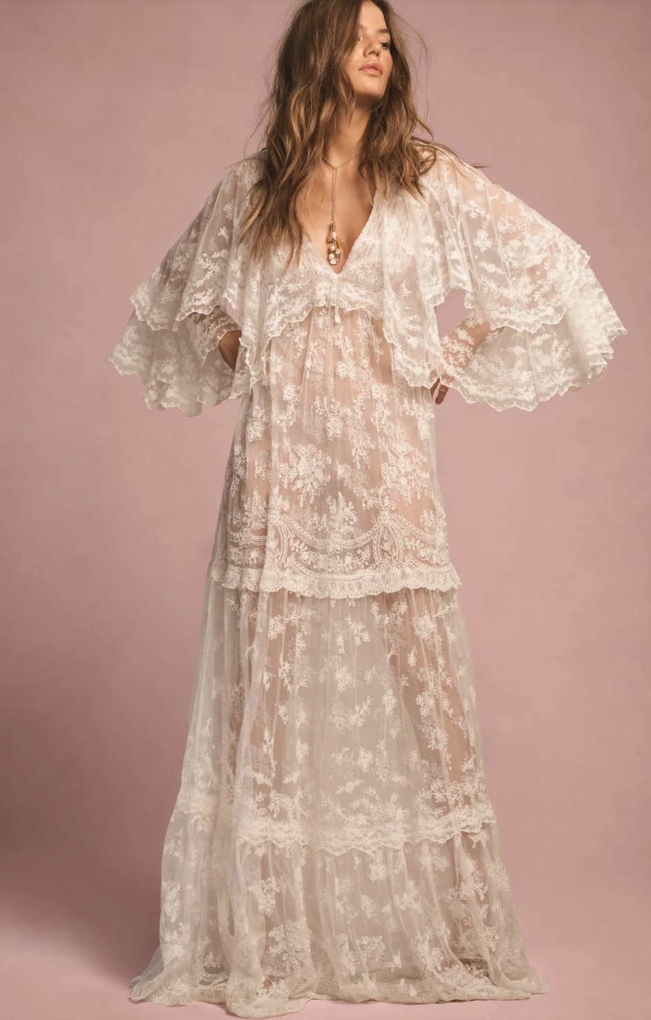 Woman wearing a floral lace dress against a pink background