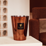 A copper alloy scented candle, with a mirrored effect, from the Baobab Collection displayed in a home setting.