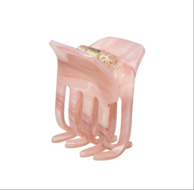 Small pink hair clip on a white background