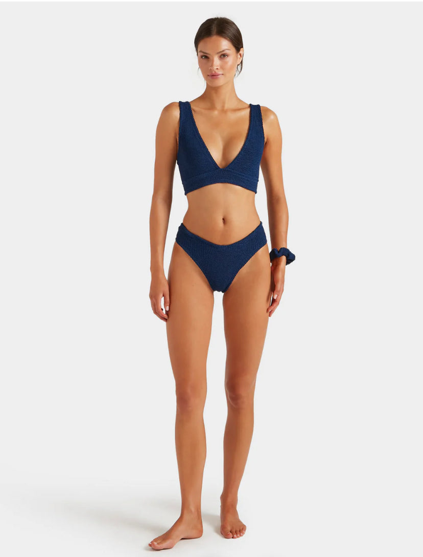 Woman wearing a navy blue bikini on a white background
