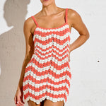 Woman wearing a red and white striped dress against a plain background
