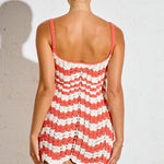 Woman wearing a red and white striped dress against a plain background