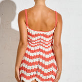 Woman wearing a red and white striped dress against a plain background
