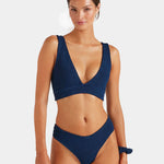 Woman wearing a blue bikini set on a white background