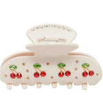 Cream hair claw clip with red cherries on a white background