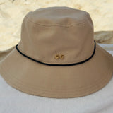 Beige bucket hat with a logo on a white surface