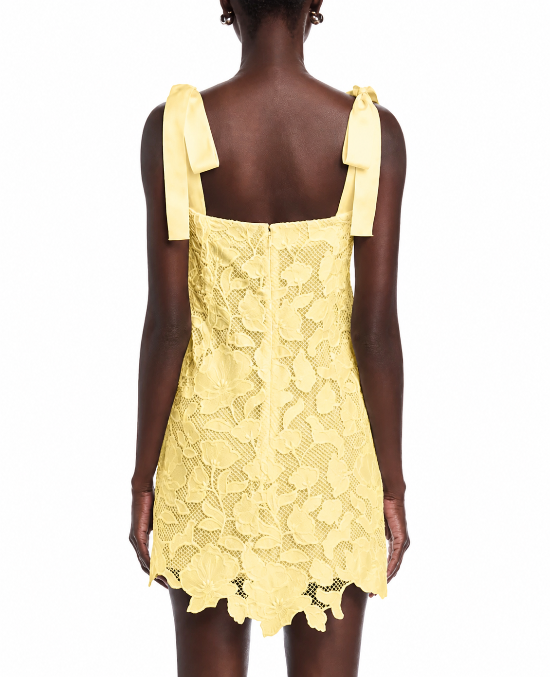 Yellow lace dress with bow straps on a white background
