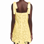 Yellow lace dress with bow straps on a white background