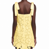 Yellow lace dress with bow straps on a white background