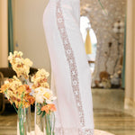 White lace-trimmed pants with a blurred background