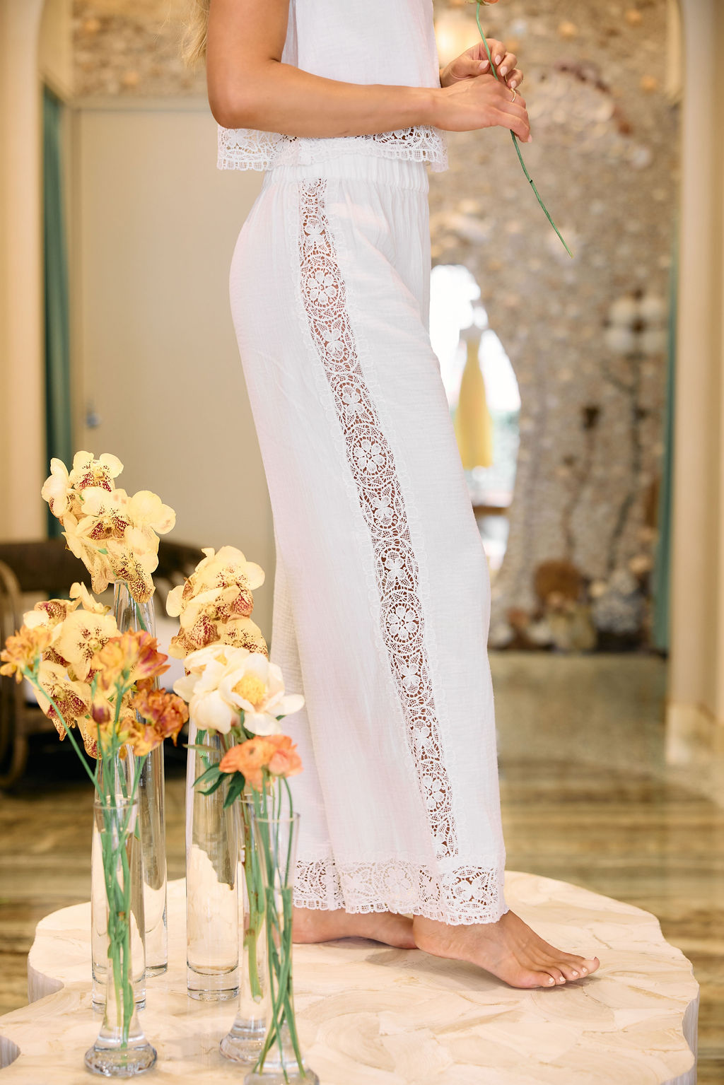 White lace-trimmed pants with a blurred background