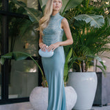 Woman in a blue dress standing among potted plants