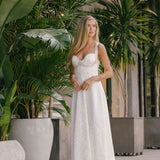 Woman in a white dress standing among potted plants