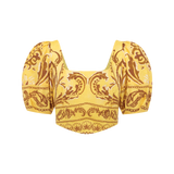 Yellow top with puff sleeves and intricate pattern on a white background