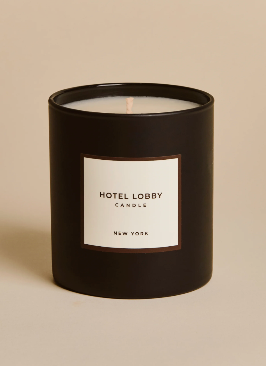 Black candle with a white label on a beige background