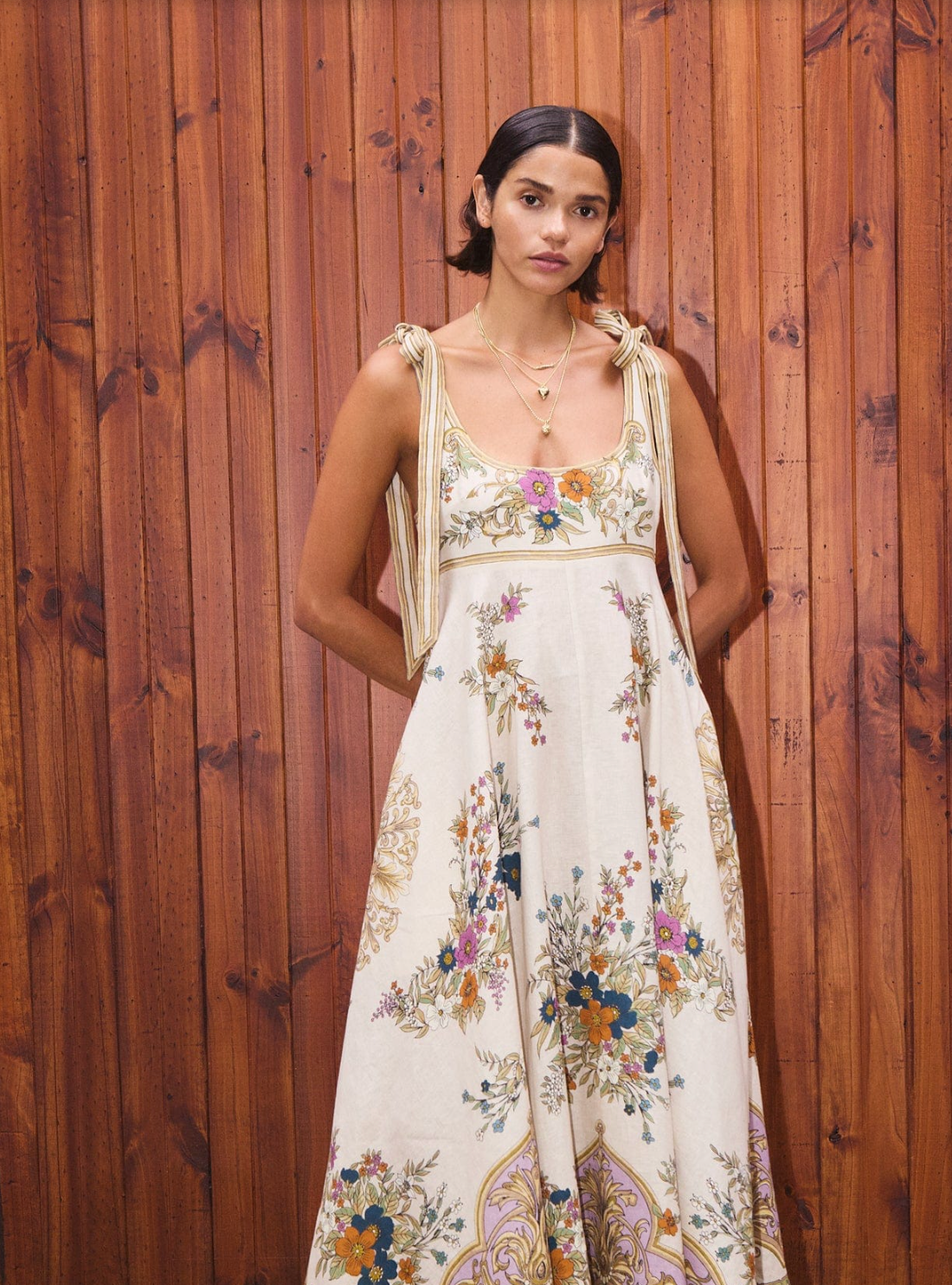 Woman wearing a floral dress against a wooden background