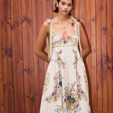 Woman wearing a floral dress against a wooden background