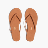 Pair of tan flip-flops with 'Tkees' branding on a white background