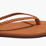 Brown sandal with braided strap on a white background