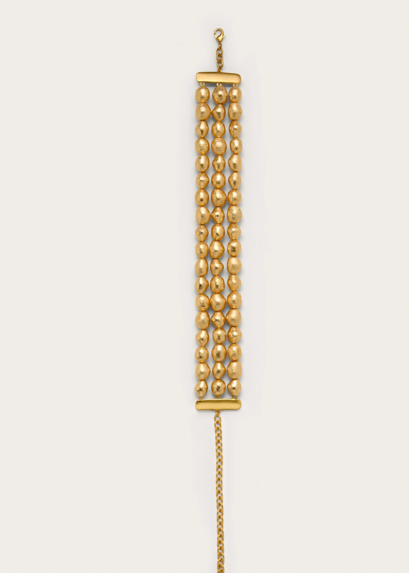 Gold chain necklace on a beige background