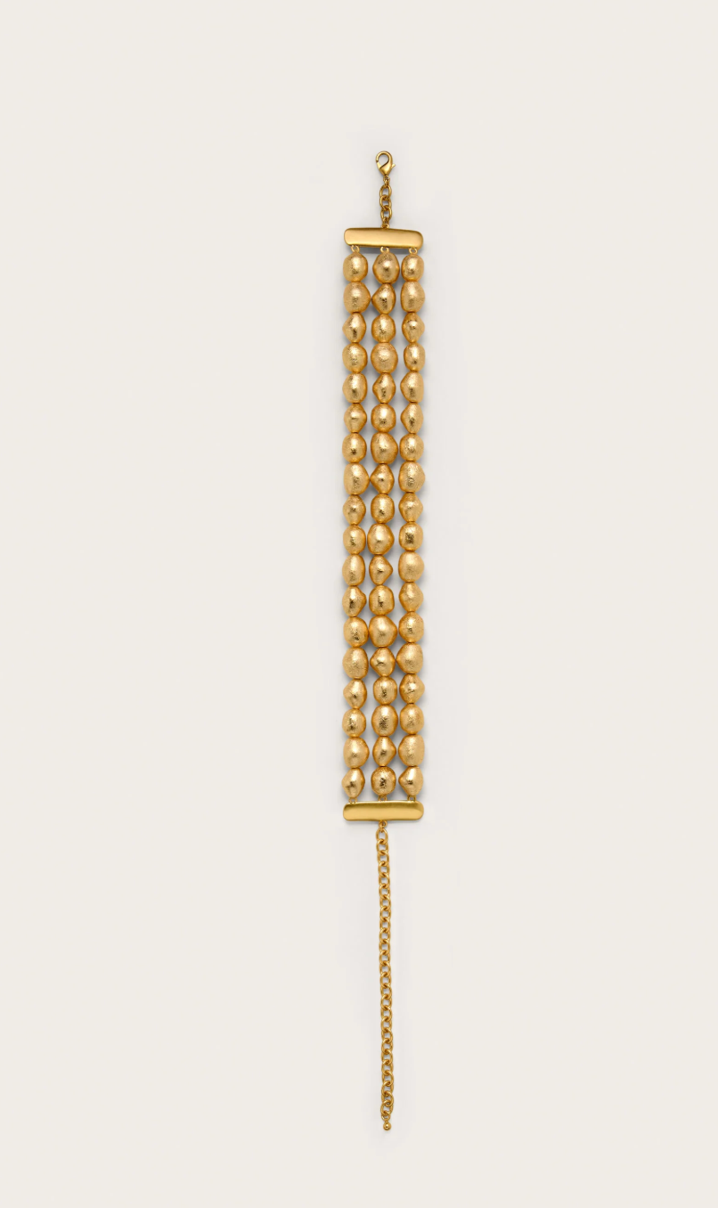 Gold chain necklace on a beige background