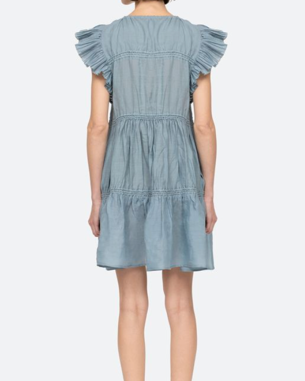 Light blue denim dress with ruffled sleeves on a white background