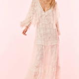 Woman wearing a white lace dress on a pink background