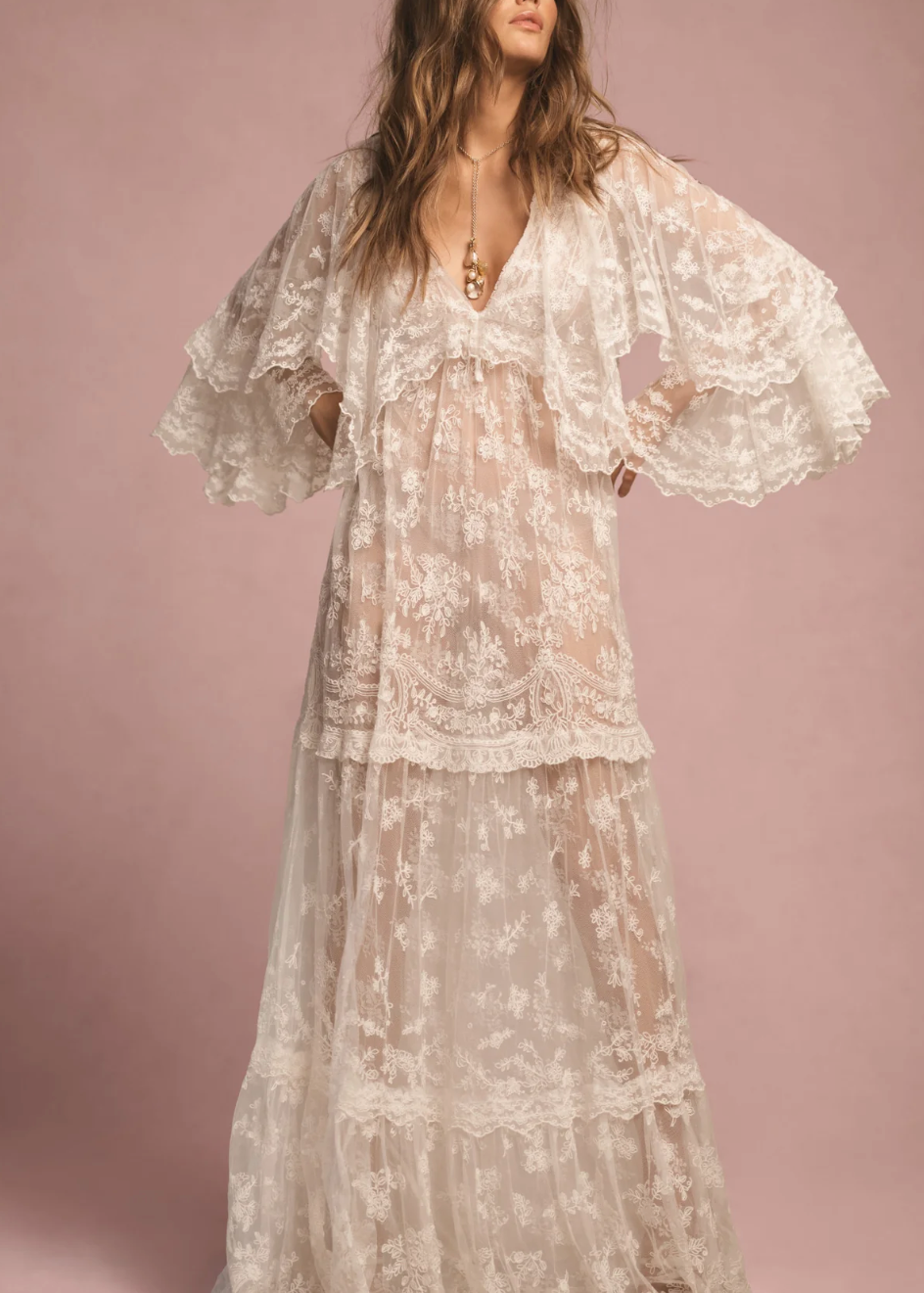 Woman wearing a floral lace dress against a pink background