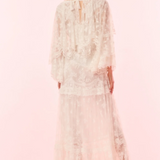 Woman wearing a floral dress on a pink background