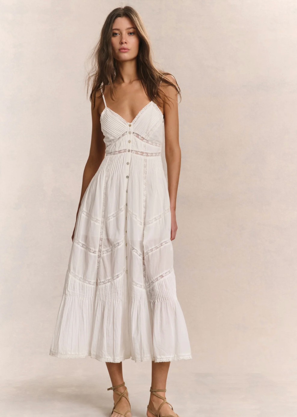 Woman wearing a white dress against a plain background