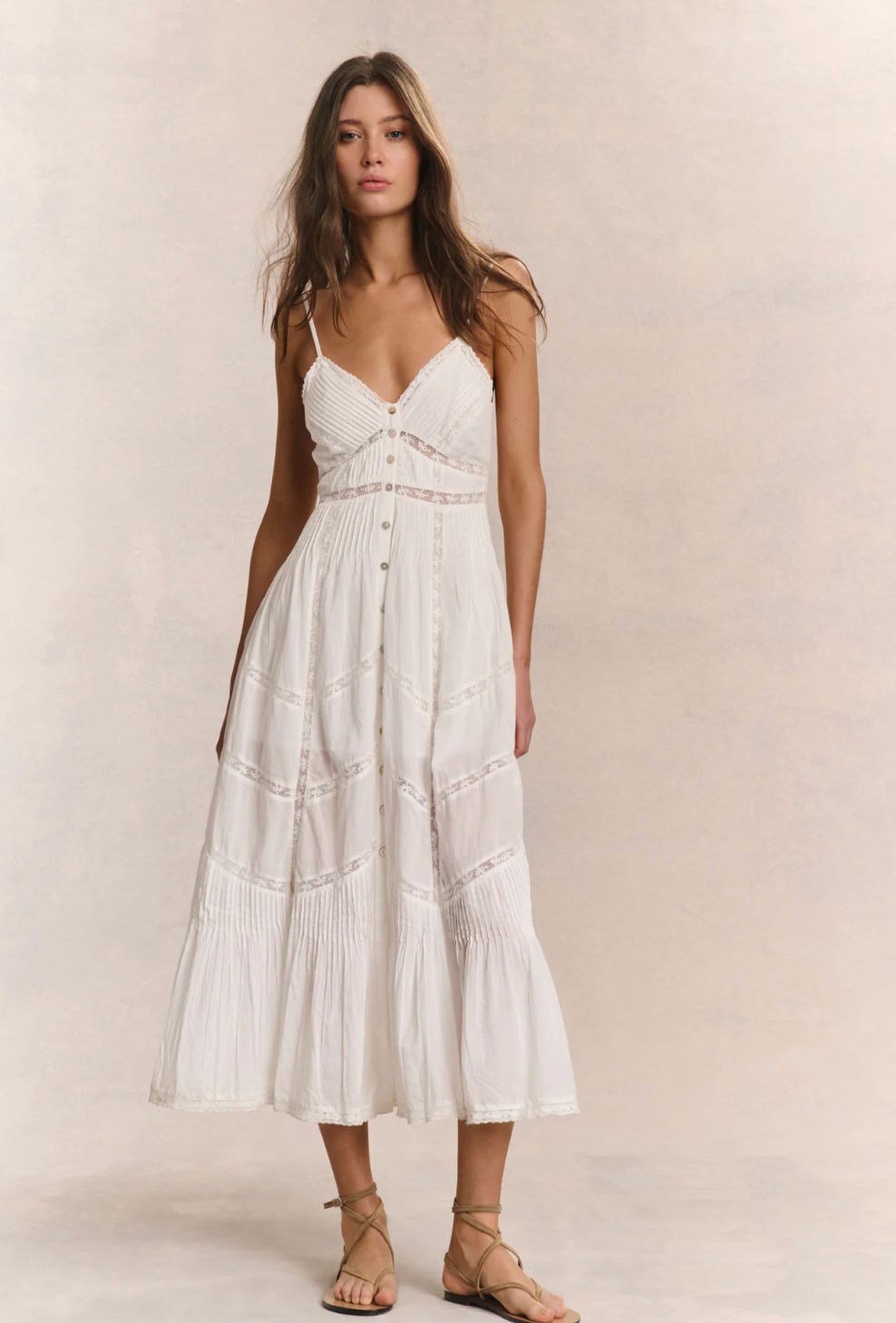 Woman wearing a white dress against a plain background