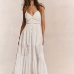 Woman wearing a white dress against a plain background