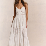 Woman wearing a white dress against a plain background