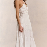 Woman wearing a white dress against a plain background