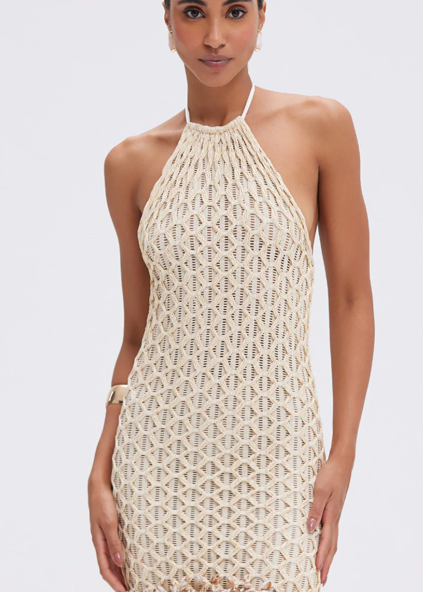 Woman wearing a beige crochet dress on a white background