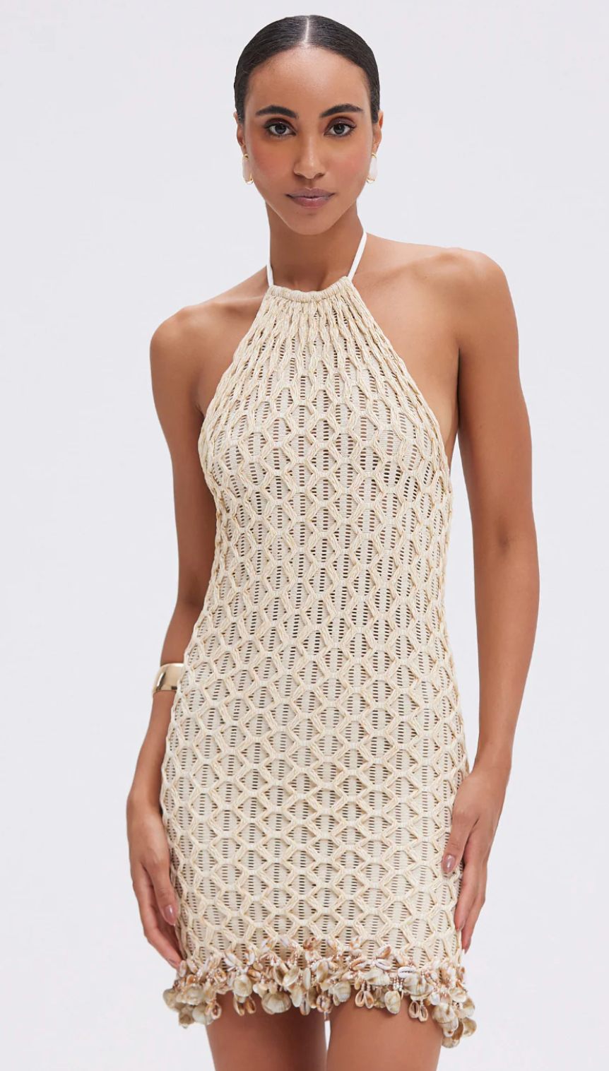 Woman wearing a beige crochet dress on a white background