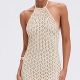 Woman wearing a beige crochet dress on a white background