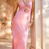 Woman in a pink dress standing outdoors near classical architecture