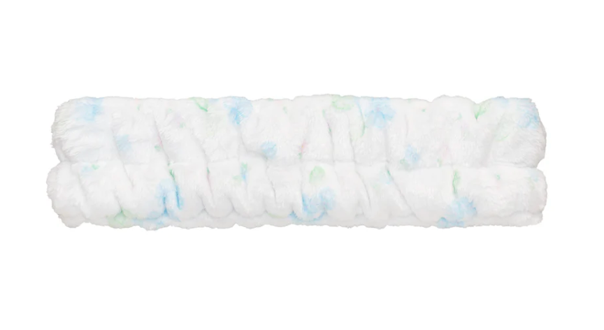 Roll of white fabric with small colorful specks on a white background