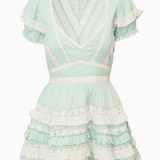 Mint green dress with ruffled layers on a white background