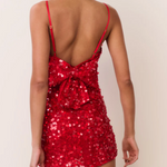 Red sequin dress with open back worn by a model on a white background
