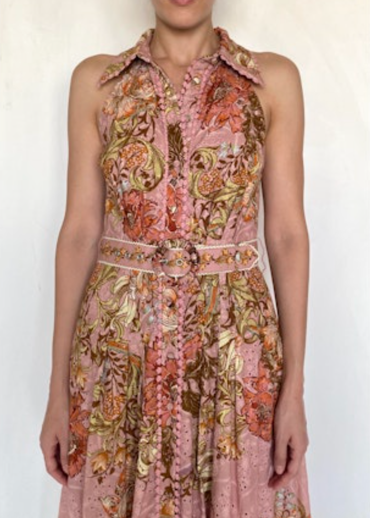 Woman wearing a sleeveless floral dress with a white background