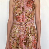 Woman wearing a sleeveless floral dress with a white background