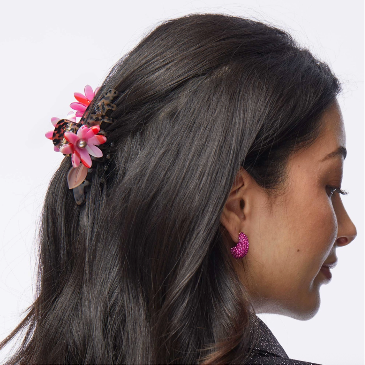 Woman with multi color floral hair accessory and earrings on a white background
